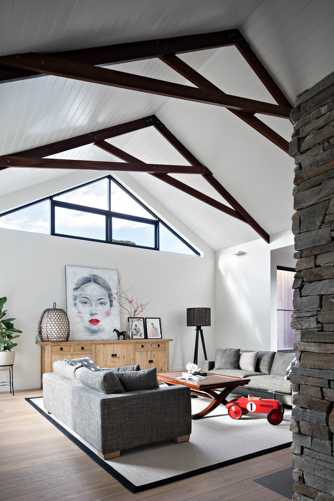 Modernes Wohnzimmer mit weißer Wandfarbe, braunem Holzboden und braunem Boden in Melbourne