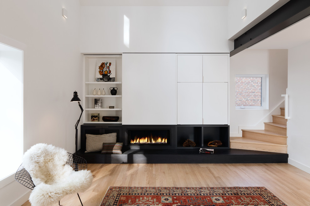 トロントにある北欧スタイルのおしゃれなオープンリビング (白い壁、内蔵型テレビ、淡色無垢フローリング、横長型暖炉、ベージュの床) の写真