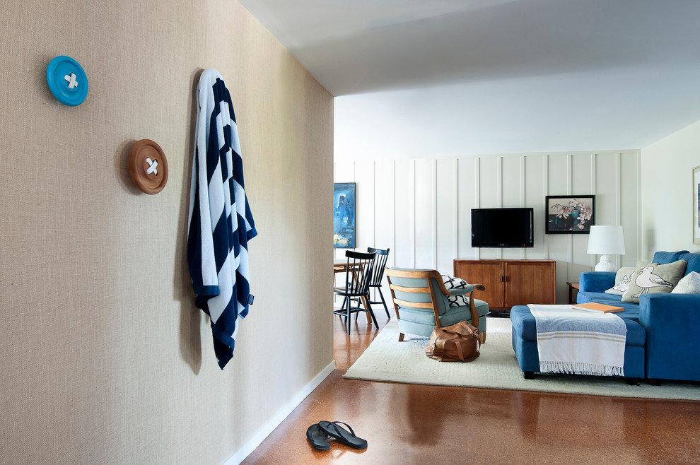 Imagen de sala de estar marinera con paredes beige, suelo de corcho y televisor colgado en la pared