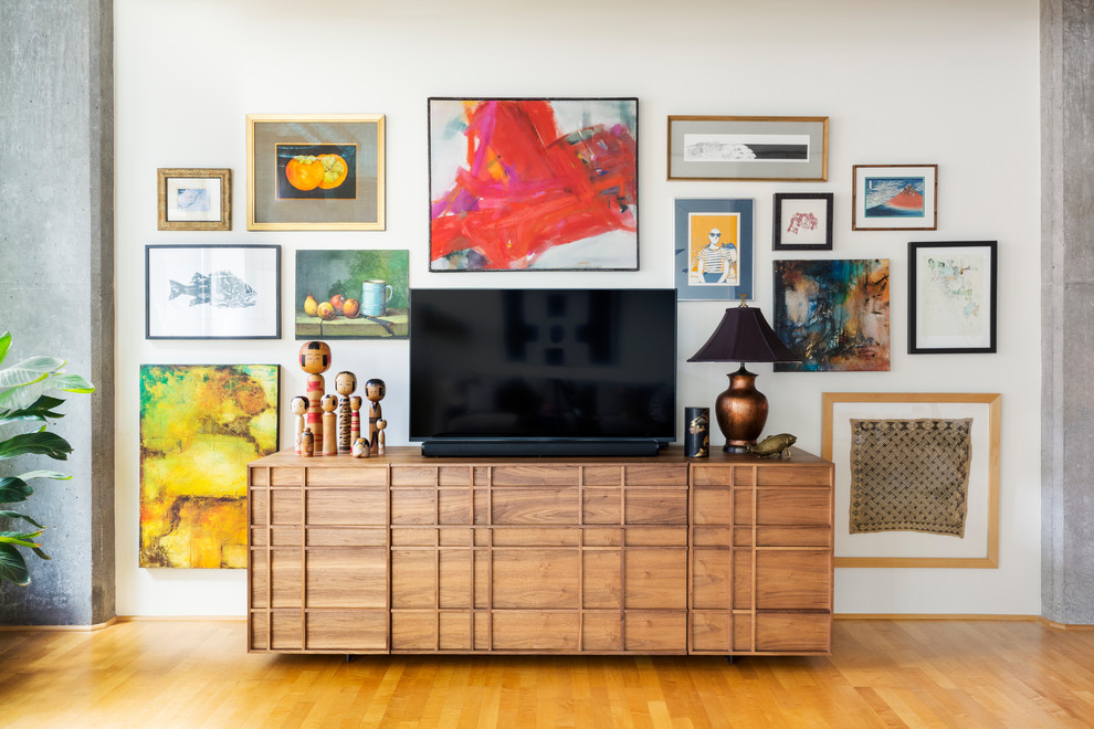 Diseño de sala de estar abierta actual con paredes blancas, suelo de madera en tonos medios y televisor independiente