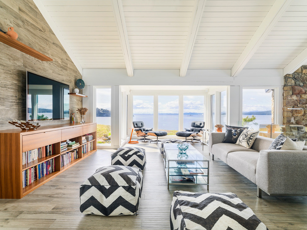 Offenes Maritimes Wohnzimmer mit weißer Wandfarbe, hellem Holzboden und TV-Wand in Vancouver