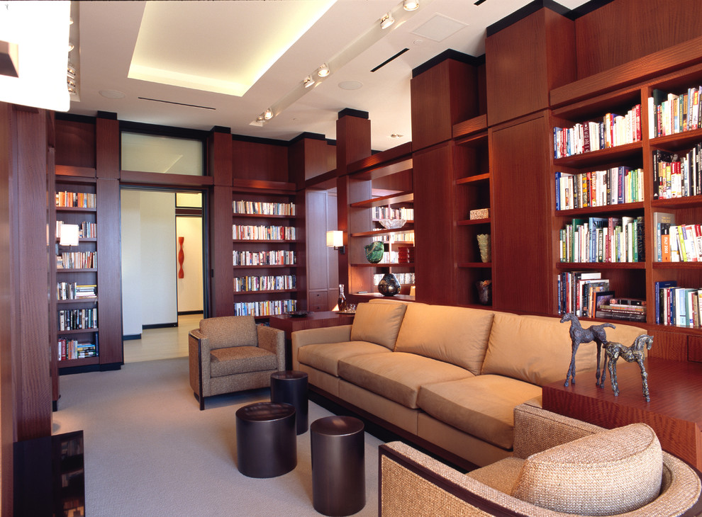 Immagine di un grande soggiorno contemporaneo chiuso con libreria, pareti marroni, moquette, camino classico e parete attrezzata