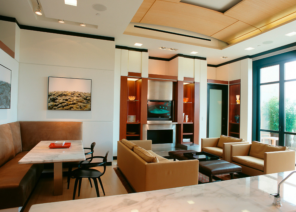 Imagen de sala de estar abierta actual grande con paredes blancas, suelo de madera clara, todas las chimeneas, marco de chimenea de metal y pared multimedia