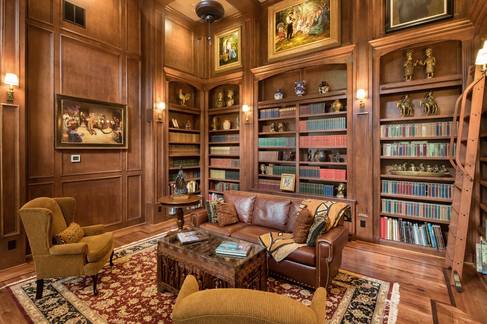 Immagine di un soggiorno vittoriano chiuso con libreria, pareti marroni, parquet scuro, nessuna TV, pavimento marrone e tappeto
