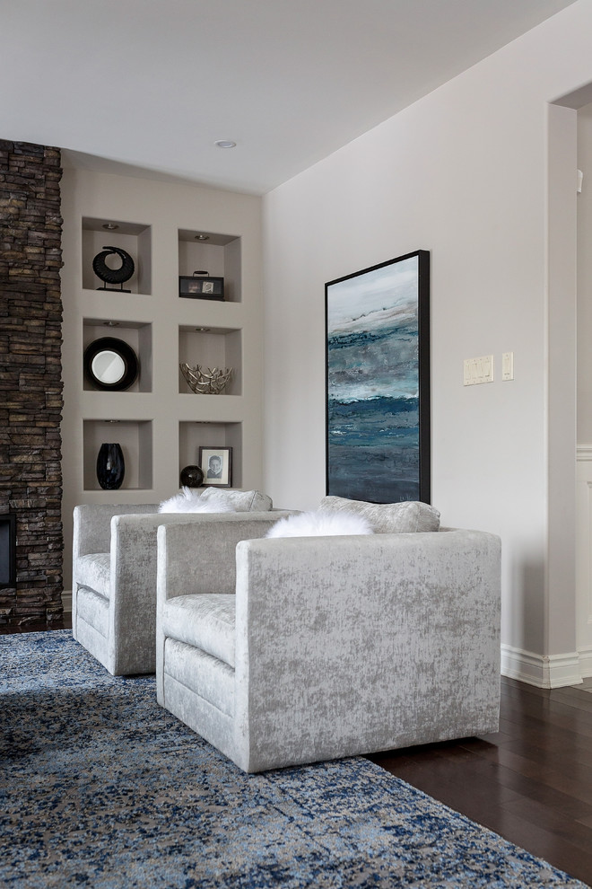 Imagen de sala de estar abierta tradicional renovada grande con paredes grises, suelo de madera oscura, todas las chimeneas, marco de chimenea de piedra y pared multimedia