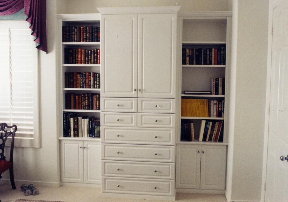Foto di un soggiorno design chiuso con libreria e TV nascosta