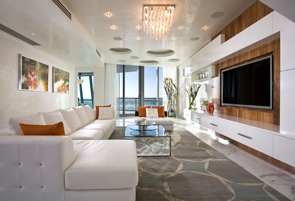 На фото: большая открытая гостиная комната в современном стиле с бежевыми стенами, ковровым покрытием, мультимедийным центром и белым полом с