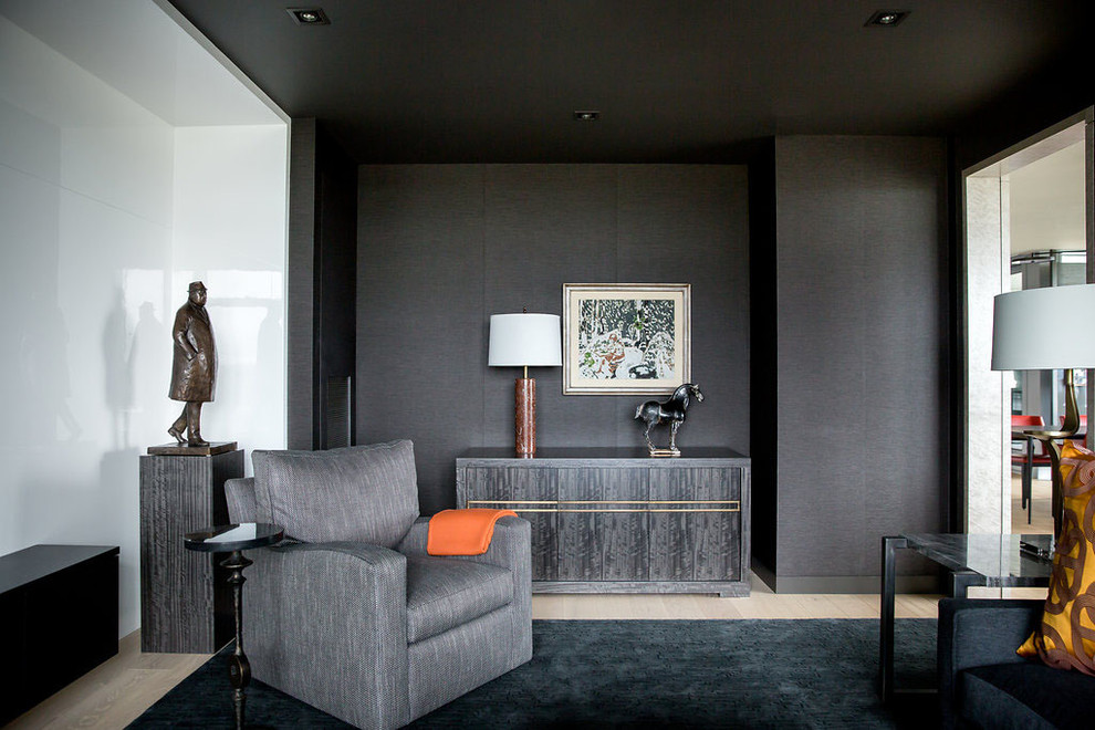 Inspiration pour une salle de séjour design de taille moyenne et fermée avec un mur noir, parquet clair et un téléviseur dissimulé.