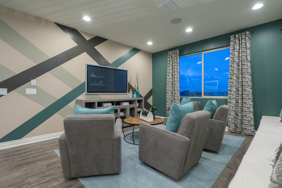 Esempio di un ampio soggiorno design stile loft con sala giochi, pareti blu, pavimento in legno massello medio, TV a parete e pavimento grigio