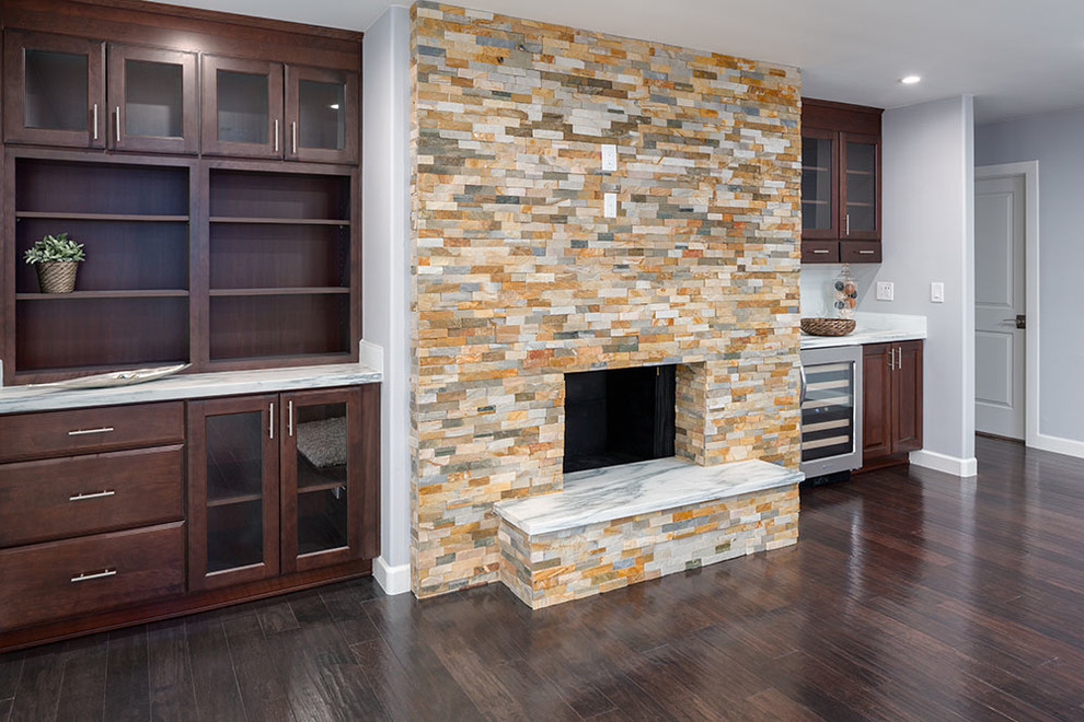 This is an example of a large contemporary open plan games room in Atlanta with a home bar, grey walls, dark hardwood flooring, a standard fireplace and a stone fireplace surround.