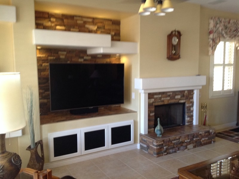 Family room - small traditional family room idea in Phoenix with a standard fireplace, a stone fireplace and a media wall