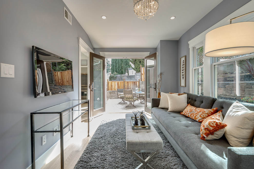Mittelgroßes, Abgetrenntes Modernes Wohnzimmer ohne Kamin mit grauer Wandfarbe, hellem Holzboden und TV-Wand in Sonstige