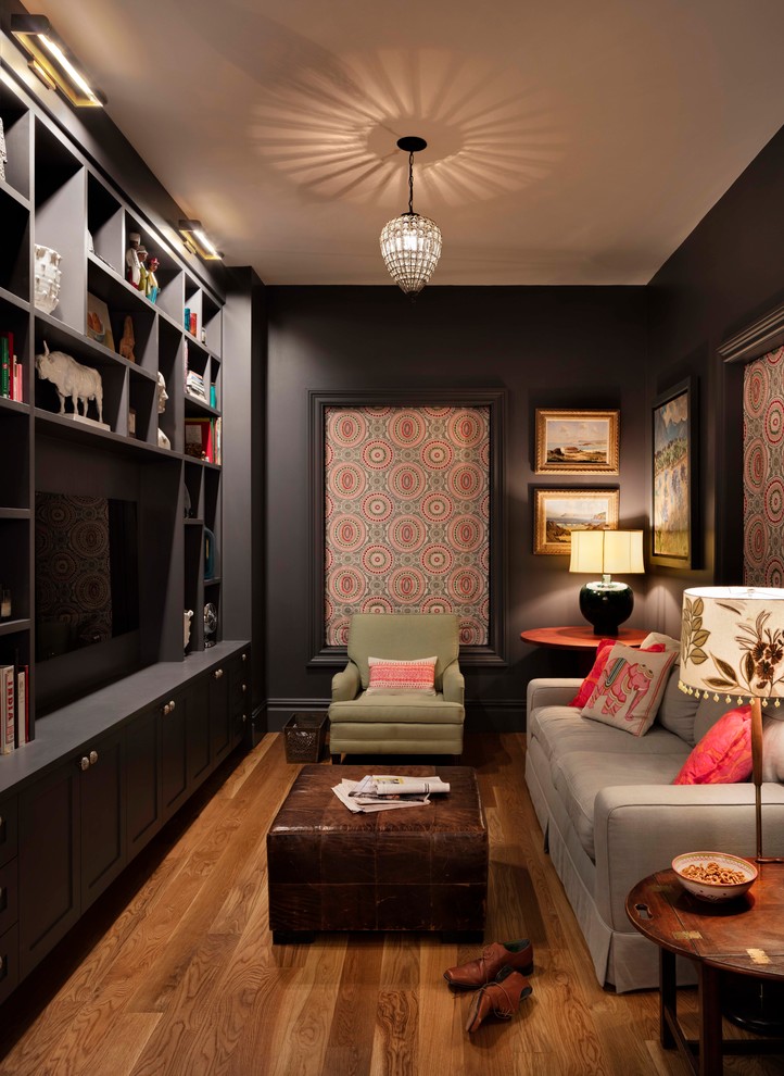 Idée de décoration pour une salle de séjour tradition avec une bibliothèque ou un coin lecture, un mur gris, un sol en bois brun, un téléviseur fixé au mur et un sol marron.