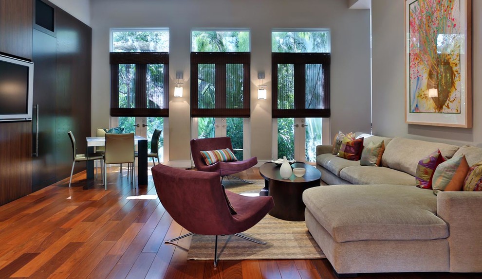 Großes, Abgetrenntes Modernes Wohnzimmer ohne Kamin mit grauer Wandfarbe, braunem Holzboden und Multimediawand in Miami