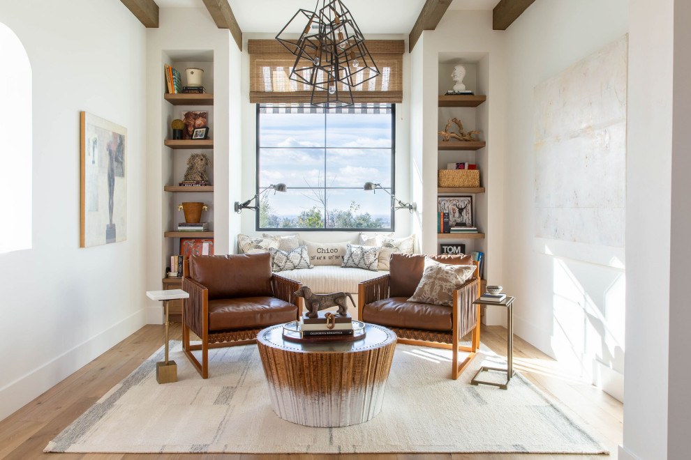 Foto de sala de estar con biblioteca cerrada mediterránea sin chimenea y televisor con paredes blancas, suelo de madera en tonos medios y suelo marrón