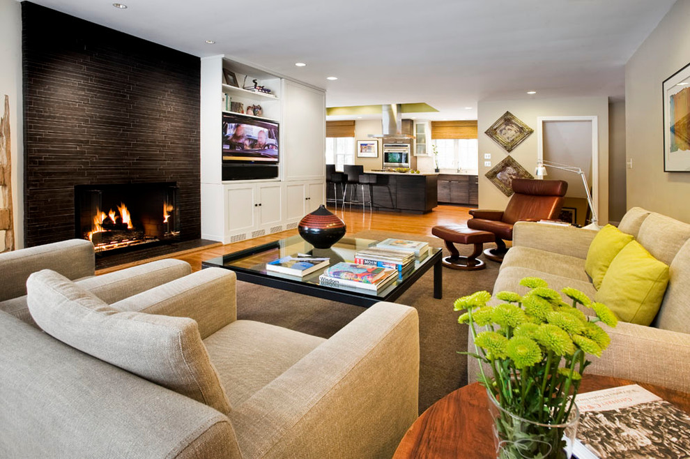 Idée de décoration pour une salle de séjour design ouverte avec un mur beige, un sol en bois brun, une cheminée standard et un téléviseur encastré.