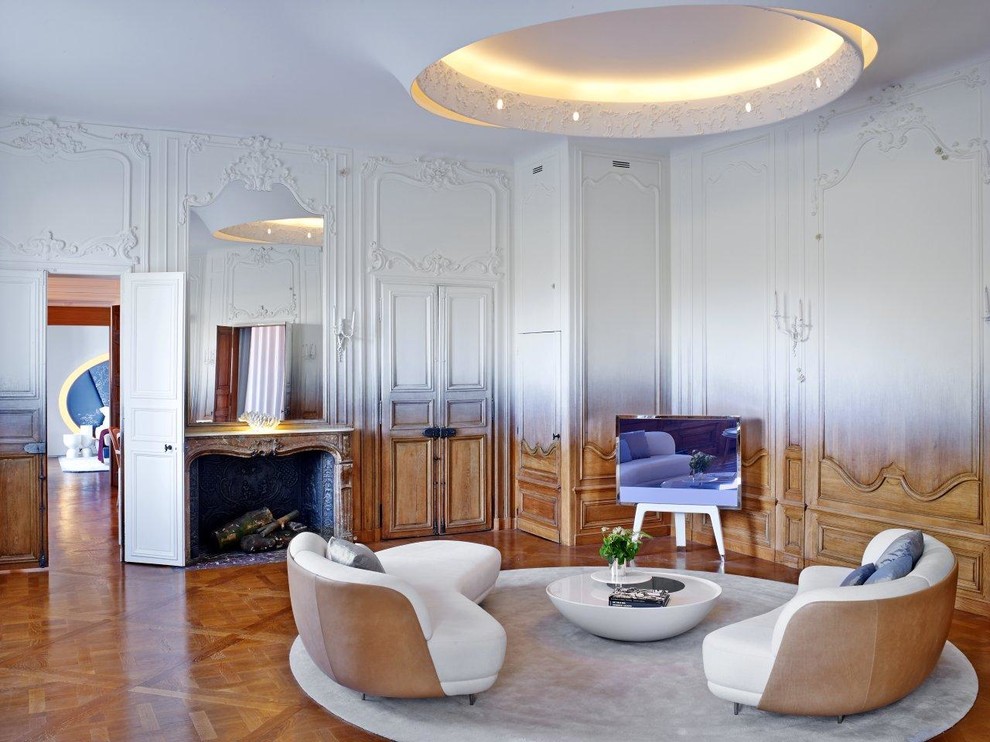 Abgetrenntes, Großes Stilmix Wohnzimmer mit bunten Wänden, braunem Holzboden, Kamin, Kaminumrandung aus Stein und freistehendem TV in Paris
