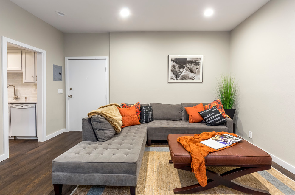 Idee per un soggiorno chic aperto e di medie dimensioni con parquet scuro, TV a parete, pareti grigie e pavimento marrone