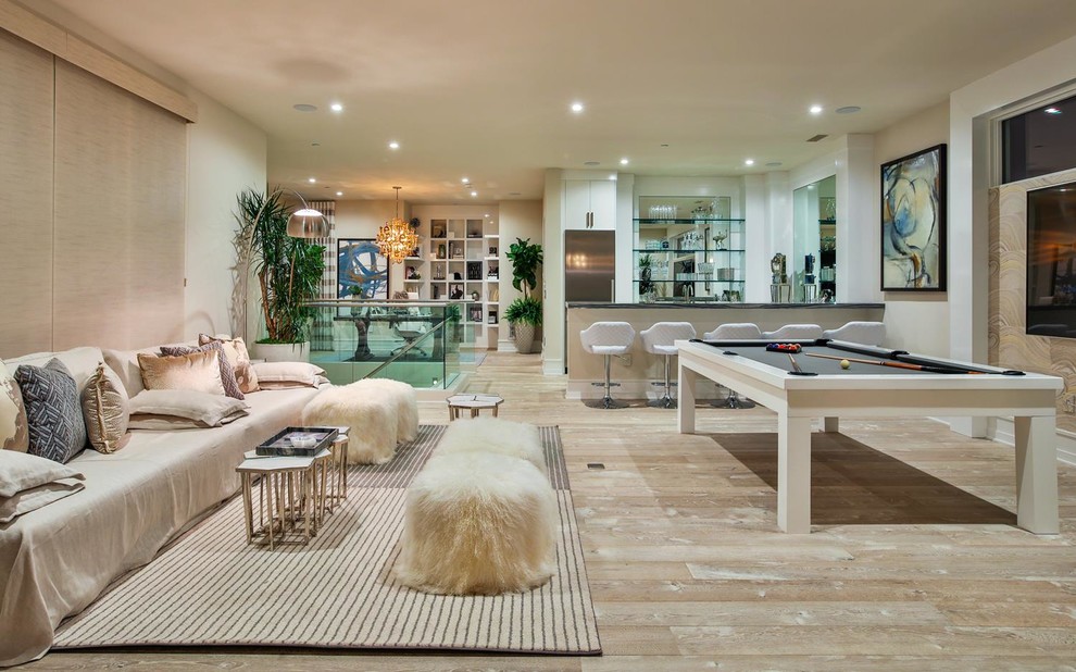 Foto di un ampio soggiorno minimalista aperto con angolo bar, pareti beige, pavimento in pietra calcarea, parete attrezzata e pavimento beige