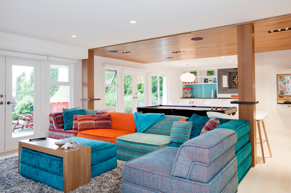 Ejemplo de sala de estar abierta contemporánea grande con paredes blancas, suelo de madera clara, pared multimedia y suelo beige