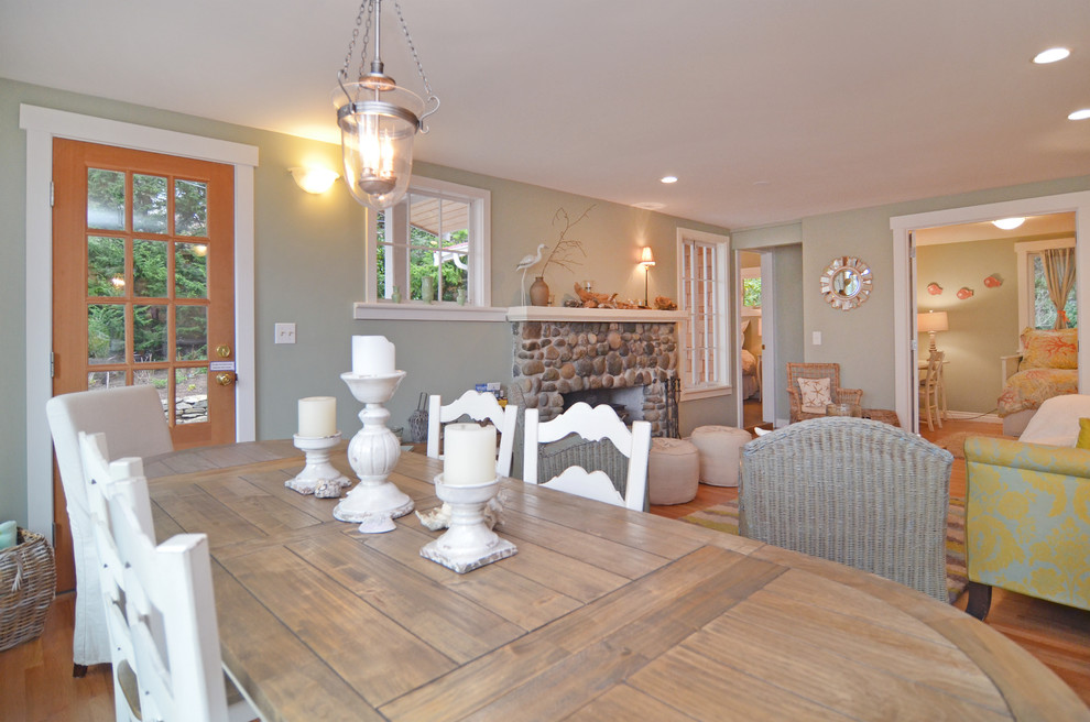 Foto de sala de estar marinera de tamaño medio con suelo de madera clara y marco de chimenea de piedra