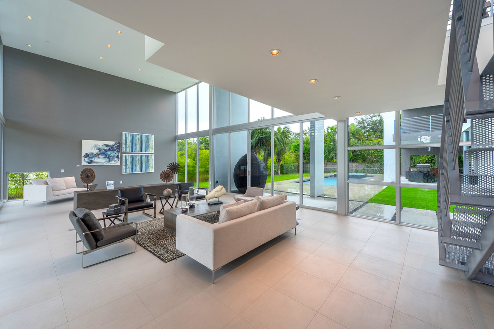 Imagen de sala de estar abierta minimalista de tamaño medio con paredes grises y suelo de baldosas de cerámica