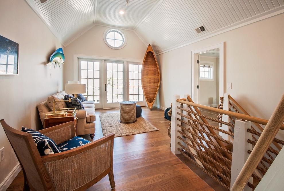 Immagine di un soggiorno costiero con pareti beige, pavimento in legno massello medio e pavimento marrone