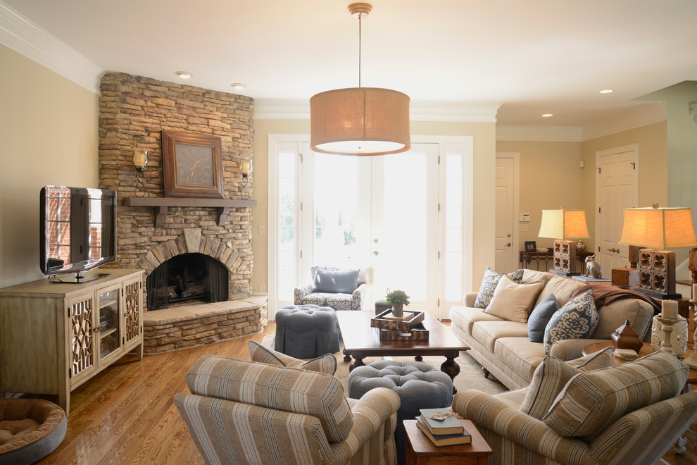 Inspiration for a mid-sized timeless open concept medium tone wood floor family room remodel in Other with beige walls, a standard fireplace, a stone fireplace and a tv stand