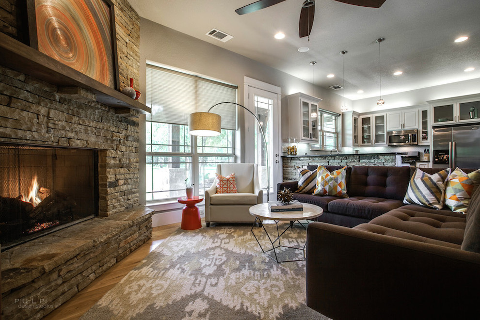 Example of an eclectic open concept medium tone wood floor family room design in Dallas with beige walls, a corner fireplace and a stone fireplace
