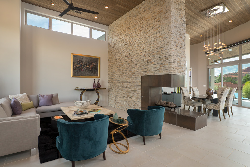 Inspiration for a large contemporary open concept porcelain tile and beige floor family room remodel in Phoenix with beige walls, a two-sided fireplace, a stone fireplace and no tv