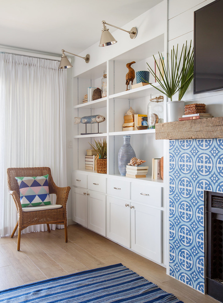 Family room - mid-sized coastal enclosed light wood floor family room idea in Jacksonville with white walls, a standard fireplace, a tile fireplace and a wall-mounted tv