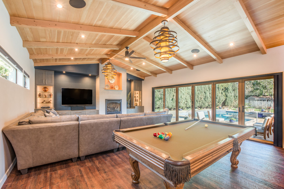 Traditional open plan games room in Sacramento with white walls, a wall mounted tv, a standard fireplace and vinyl flooring.