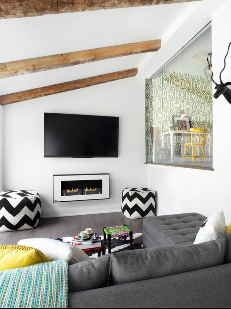 Bild på ett funkis allrum, med vita väggar, mörkt trägolv, en bred öppen spis och en väggmonterad TV