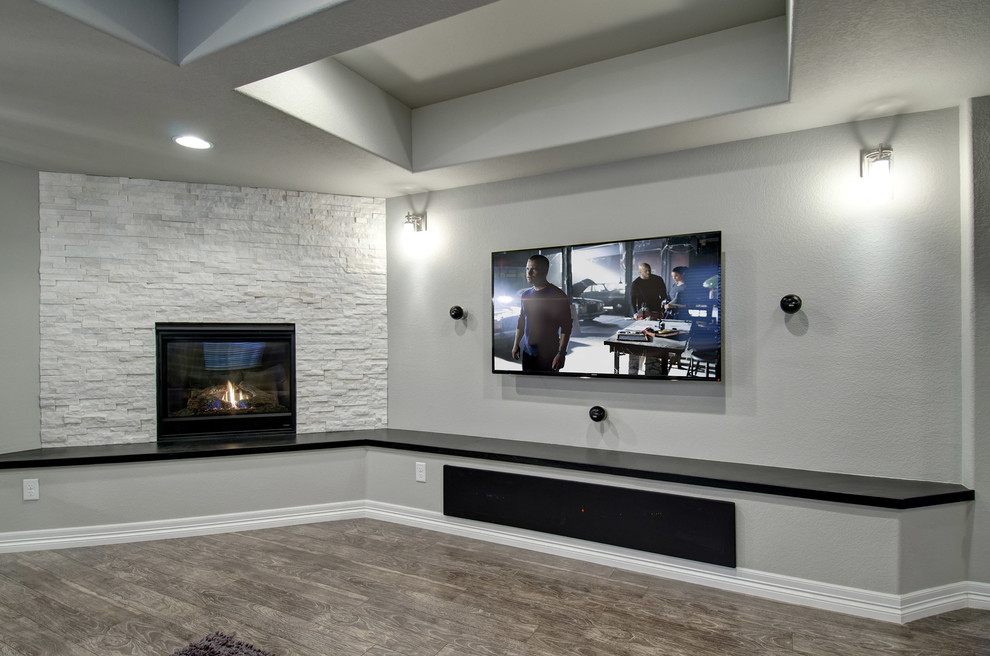 Großes, Offenes Modernes Wohnzimmer mit Hausbar, grauer Wandfarbe, dunklem Holzboden, Kamin, Kaminumrandung aus Stein, TV-Wand und braunem Boden in Denver