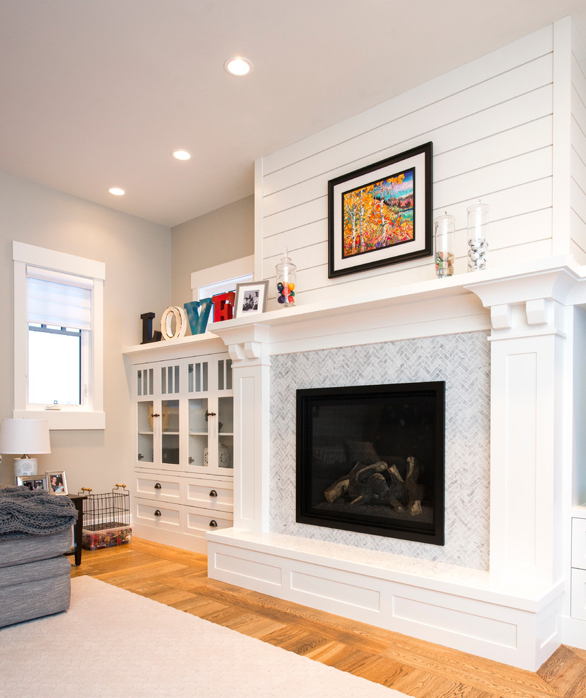 Example of a large transitional enclosed medium tone wood floor family room design in Calgary with beige walls, a standard fireplace, a tile fireplace and a media wall