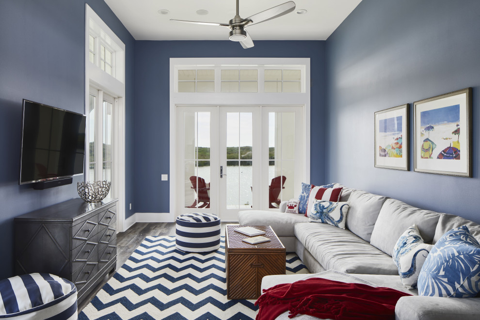 На фото: изолированная комната для игр среднего размера в морском стиле с полом из винила, телевизором на стене, коричневым полом и синими стенами