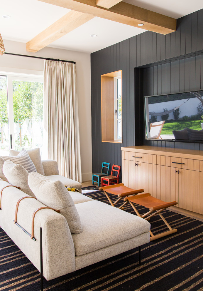 Ejemplo de sala de estar marinera con paredes beige, suelo de madera en tonos medios, televisor colgado en la pared y suelo marrón