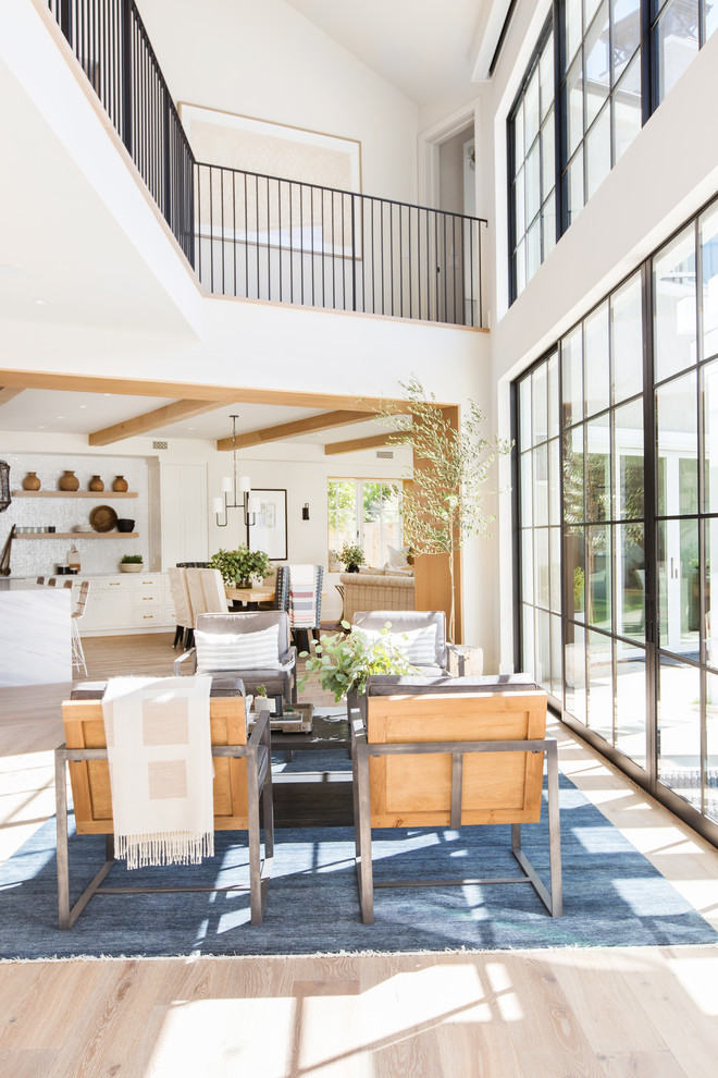 Offenes Maritimes Wohnzimmer mit weißer Wandfarbe, hellem Holzboden und beigem Boden in Orange County