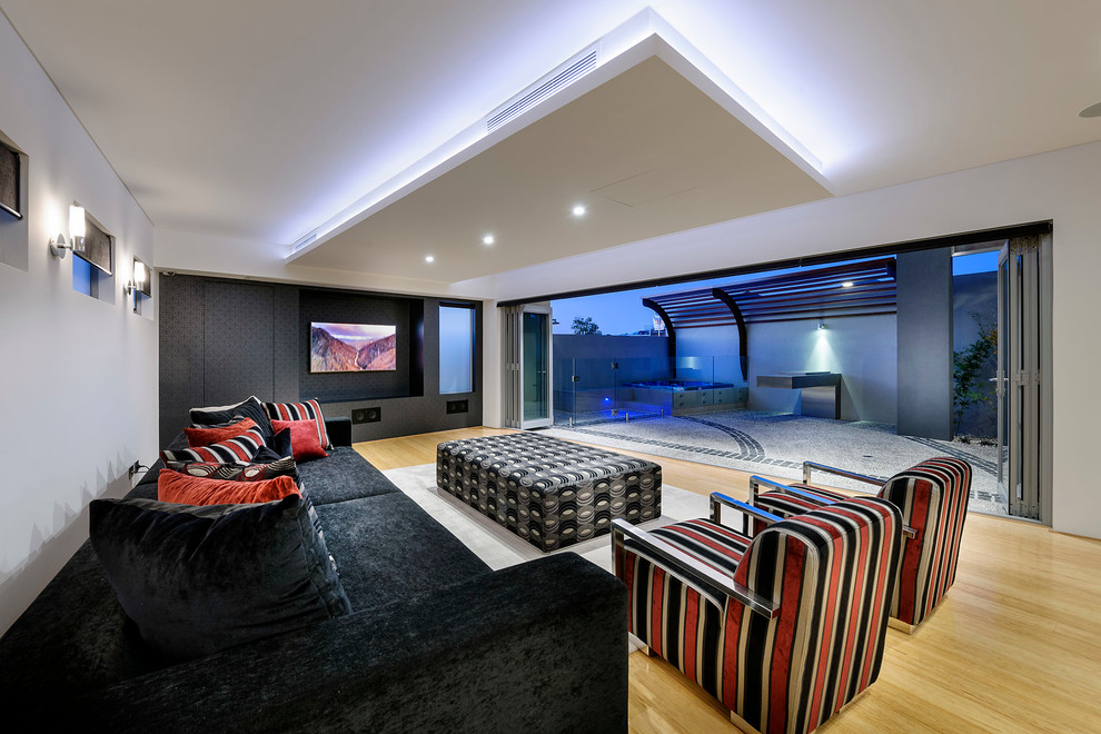 Foto de sala de estar abierta actual con paredes blancas, suelo de madera clara y pared multimedia