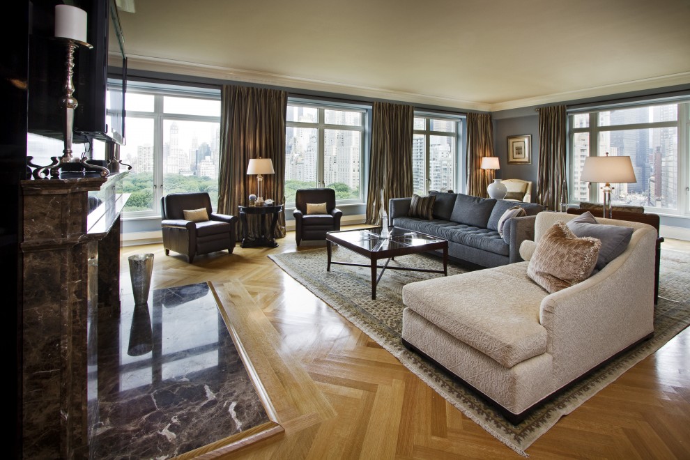 Ejemplo de sala de estar tradicional con paredes grises, suelo de madera en tonos medios, todas las chimeneas y marco de chimenea de piedra