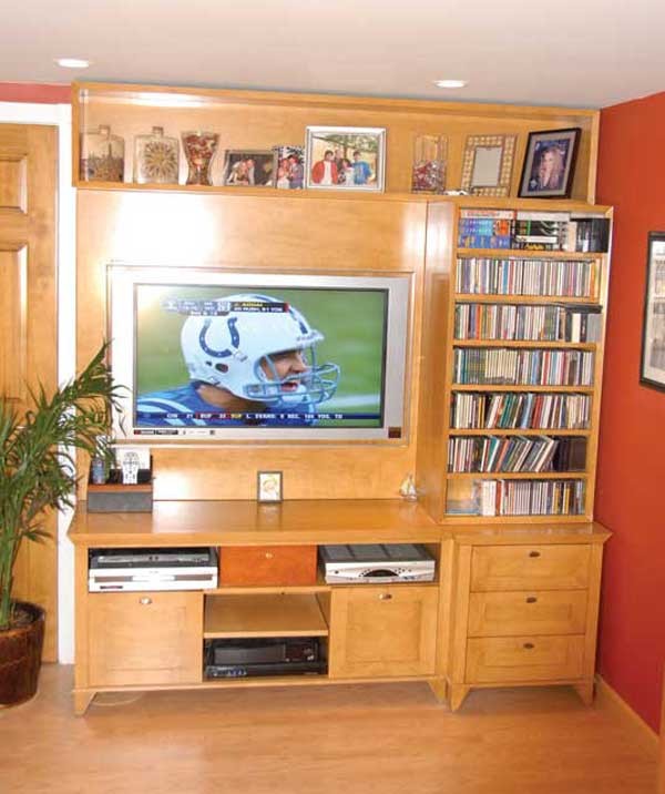 Inspiration for a medium sized contemporary enclosed games room in New York with orange walls, light hardwood flooring, no fireplace and a built-in media unit.