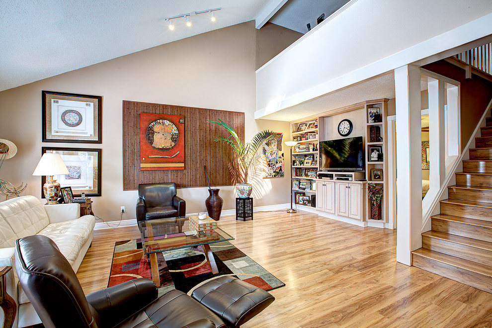 Modelo de sala de estar abierta tradicional con paredes beige, suelo de madera en tonos medios y televisor independiente