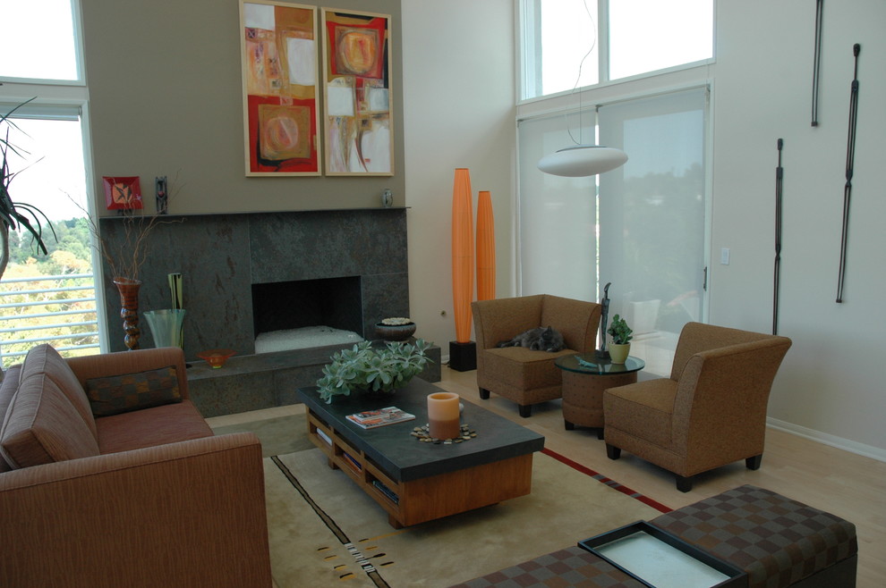 Modernes Wohnzimmer mit beiger Wandfarbe, hellem Holzboden, Kamin und Kaminumrandung aus Stein in Los Angeles