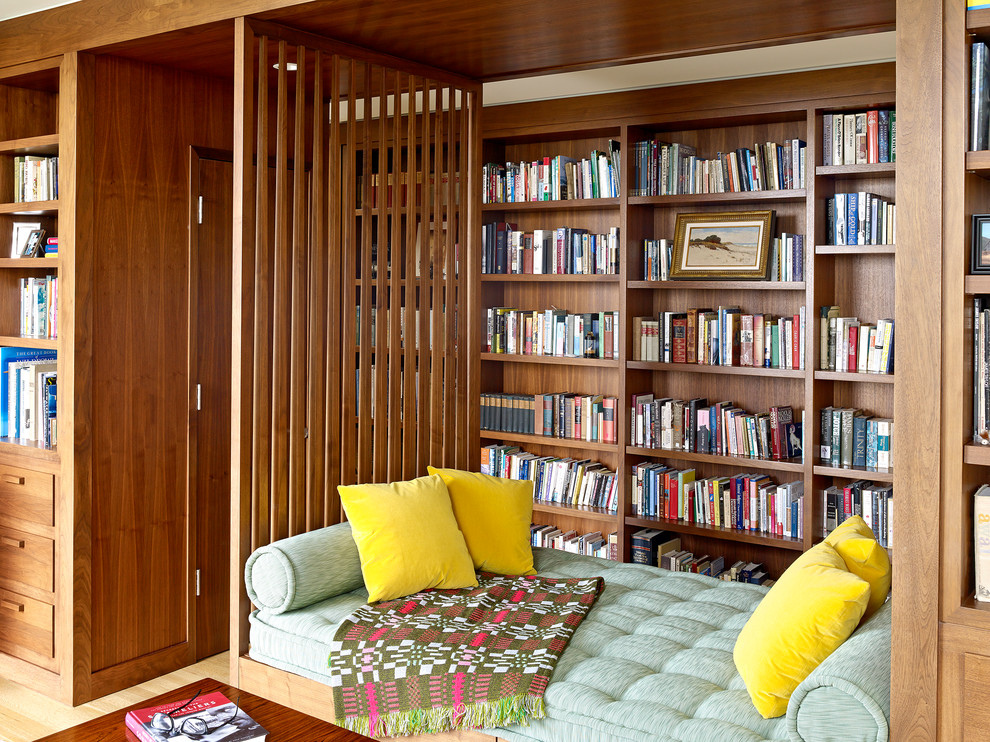 Aménagement d'une salle de séjour contemporaine avec une bibliothèque ou un coin lecture, parquet clair et un sol beige.