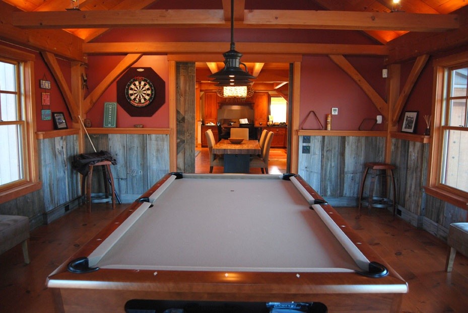 Modelo de sala de juegos en casa cerrada clásica de tamaño medio sin chimenea con paredes rojas y suelo de madera en tonos medios