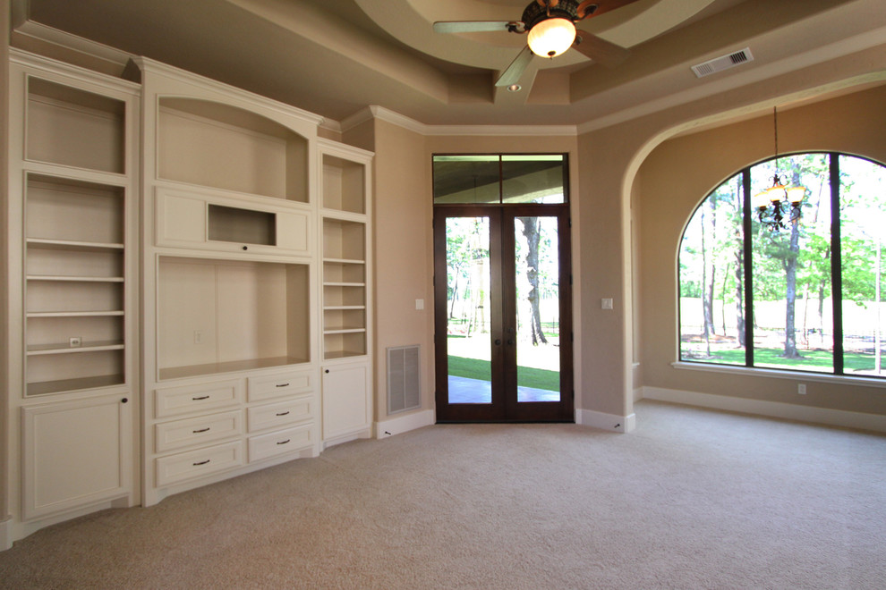 Inspiration for a mediterranean carpeted family room remodel in Houston with beige walls and a media wall