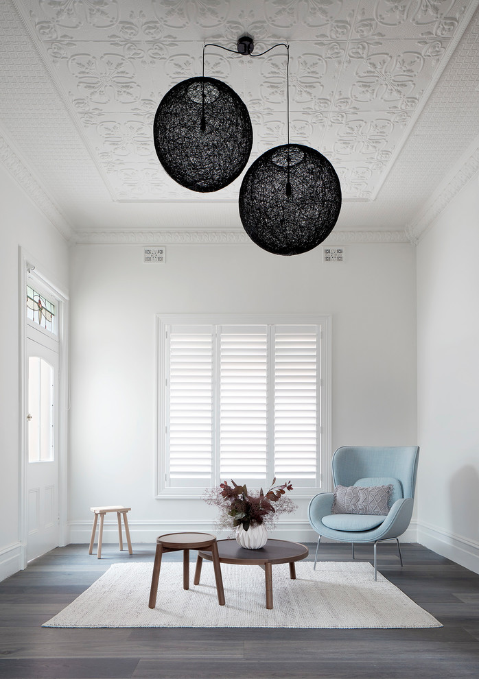 Immagine di un soggiorno minimal di medie dimensioni e aperto con pareti bianche, parquet chiaro, TV a parete e pavimento grigio