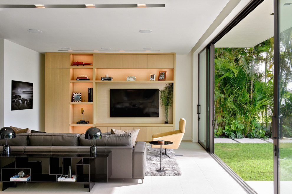 Inspiration for a contemporary white floor family room remodel in Miami with white walls and a media wall