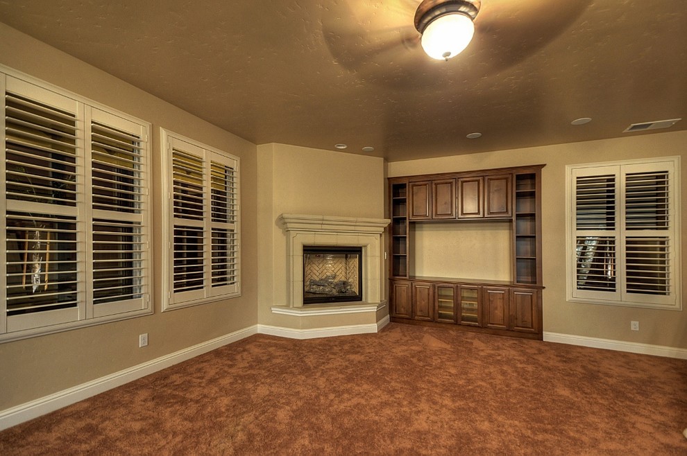 Large classic open plan games room in Austin with a reading nook, beige walls, carpet, a corner fireplace, a stone fireplace surround and a built-in media unit.