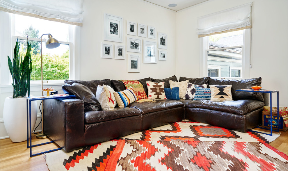 Imagen de sala de estar cerrada bohemia pequeña con paredes blancas, suelo de madera en tonos medios, televisor colgado en la pared y suelo marrón
